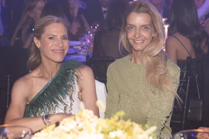 Top con escote asimétrico y plumas para Eugenia Anzorreguy, que charla animadamente con Carla Piccolomini