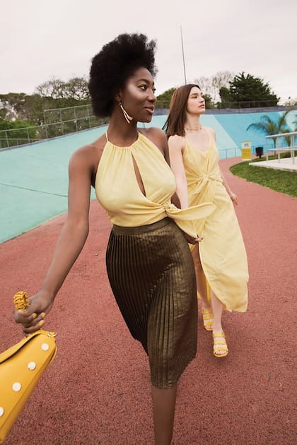 Top y aros (Vitamina), falda plisada (Prüne) y cartera (Blaquè). Vestido largo (Vitamina), sandalias charoladas (Prüne) y collar con dijes (Rapsodia)