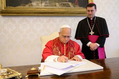 TOPSHOT - This photo taken on May 15, 2026 and handout on May 25, 2025 by The Vatican Media shows Pope Leo XIV signing his first Encyclical Letter “Magnifica Humanitas”, focused on the rise of artificial intelligence, in The Vatican. (Photo by Handout / VATICAN MEDIA / AFP) / RESTRICTED TO EDITORIAL USE - MANDATORY CREDIT "AFP PHOTO / VATICAN MEDIA" - NO MARKETING - NO ADVERTISING CAMPAIGNS - DISTRIBUTED AS A SERVICE TO CLIENTS