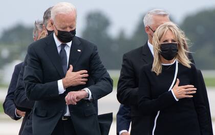 TOPSHOT - US President Joe Biden looks down alongside First Lady Jill Biden as they attend the dignified transfer of the remains of a fallen service member at Dover Air Force Base in Dover, Delaware, August, 29, 2021, one of the 13 members of the US military killed in Afghanistan last week. - President Joe Biden prepared Sunday at a US military base to receive the remains of the 13 American service members killed in an attack in Kabul, a solemn ritual that comes amid fierce criticism of his handling of the Afghanistan crisis. Biden and his wife, Jill, both wearing black and with black face masks, first met far from the cameras with relatives of the dead in a special family center at Dover Air Force Base in Delaware.The base, on the US East Coast about two hours from Washington, is synonymous with the painful return of service members who have fallen in combat. (Photo by SAUL LOEB / AFP)
