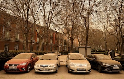 Una fila de autos cubiertos por arena en Madrid