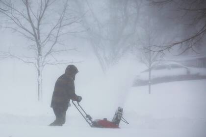 Una persona intenta despeja la nieve de su patio 