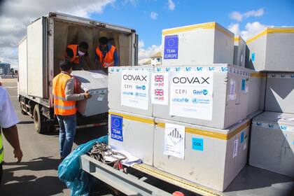 Trabajadores cargan cajas con la vacuna de Oxford/AstraZeneca distribuida por el programa COVAX, en Madagascar.