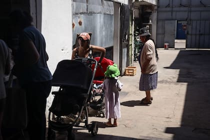 Trabajadores de cooperativas, personas en situación de calle y vecinos de la villa 1-11-14 se acercan a "Olla Talleres" para llevarse una ración de comida