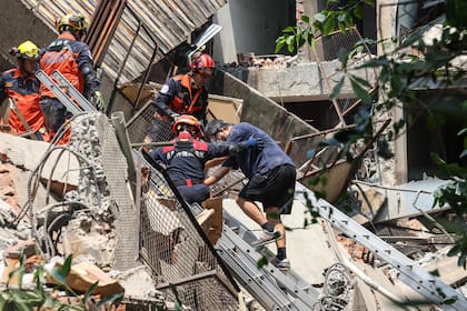 Trabajadores de emergencia ayudan a un sobreviviente después de que fue rescatado de un edificio dañado en la ciudad de Nuevo Taipei