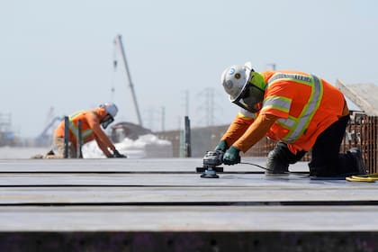 Trabajadores de la Autoridad Ferroviaria de Alta Velocidad de California trabajan en el Viaducto Hanford, el martes 15 de abril de 2025