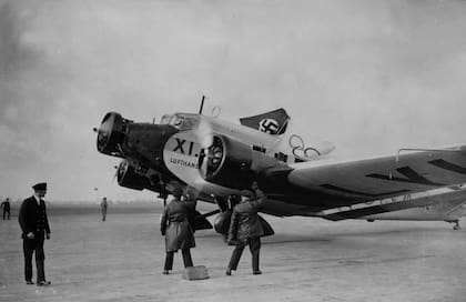 Trabajadores de la compañía aérea alemana Deutsche Lufthansa realizan el saludo nazi durante la llegada de un avión con la bandera del Tercer Reich y el emblema del Comité Olímpico Alemán al aeródromo de Croydon, el 2 de diciembre de 1935 (Fotografía: J. A. Hampton (Getty Images)