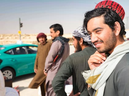 Trabajadores de la construcción afganos esperan un Uber que los traslade hacia su casa, en las afueras de Riyadh.