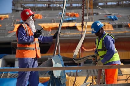 rabajadores de la construcción en el estadio icónico de Lusail en Doha, Qatar.