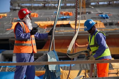 Trabajadores de la construcción en el estadio icónico de Lusail en Doha, Qatar.