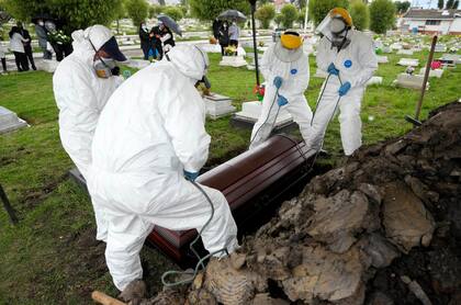 Trabajadores de un cementerio mueven un féretro con los restos de un hombre que murió a causa del Covid-19, en el cementerio de Zipaquira, en Zipaquira, Colombia, el 18 de junio de 2021