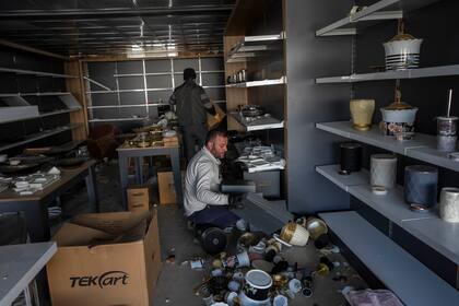 Trabajadores de un negocio de diseño interior recuperan ítems que no fueron afectados por el sismo, en Antakya, Turquía