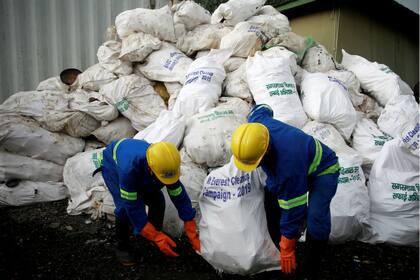 Trabajadores de una empresa de reciclaje cargan la basura recolectada y traída del monte Everest en Katmandú, Nepal