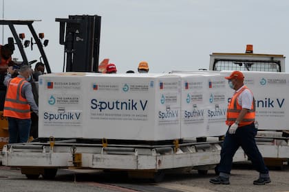 Trabajadores del aeropuerto venezolano colocan en un camión refrigerado paquetes que contienen 100.000 dosis de la vacuna rusa Sputnik V contra el coronavirus en el aeropuerto internacional Simón Bolívar de La Guaria, Venezuela el 13 de febrero de 2021