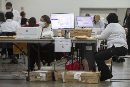 Trabajadores del departamento de elecciones de Detroit procesan los votos anticipados
