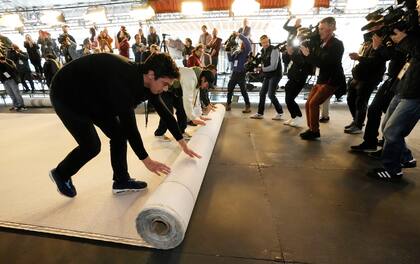 Trabajadores desenrollan la alfombra durante los preparativos para la 95a edición de los Premios de la Academia, el 8 de marzo de 2023

