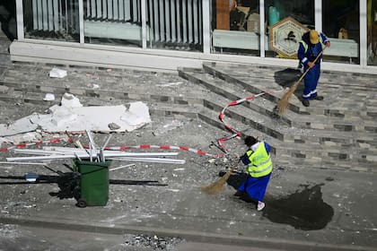 Trabajadores despejan los escombros que quedaron tras el impacto de un dron
(Daniel MIHAILESCU / AFP)