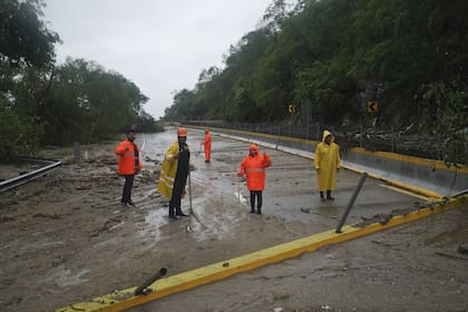 Trabajadores despejan una carretera bloqueada tras el paso del huracán Otis cerca de Acapulco, México, miércoles 25 de octubre de 2023. (AP/Marco Ugarte)