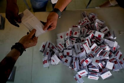 Trabajadores electorales abren los votos para el conteo tras el cierre de urnas en Santiago, Chile, el domingo 17 de diciembre de 2023