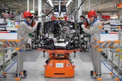 Trabajadores en una fábrica de automóviles en Tianjin, China. La economía del gigante asiático frenó su crecimiento