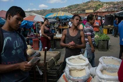 Trabajadores esperan a los clientes en su puesto de verduras en un mercado mayorista de alimentos en Caracas, Venezuela, el 28 de enero.