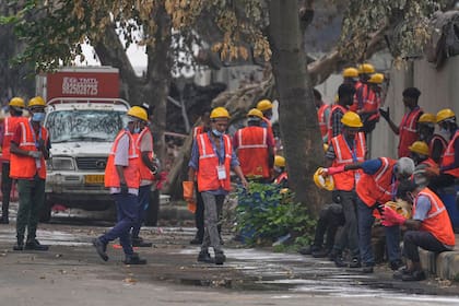 Trabajadores locales descansan cerca del sitio del choque mortal de un avión de Air India en Ahmedabad, India, el lunes 16 de junio de 2025.
