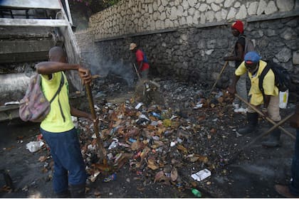 Trabajadores municipales limpian las calles de Puerto Príncipe, luego de diez días de disturbios
