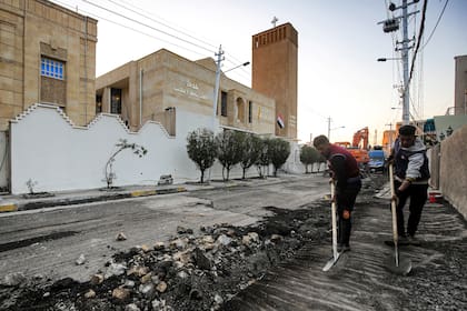 Trabajadores municipales pavimentan el camino frente a la Iglesia Católica Caldea de San José en la capital de Irak, Bagdad, el 27 de febrero de 2021, en medio de los preparativos para la visita del Papa Francisco en marzo