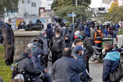 Los trabajadores portuarios esperan en la entrada del puerto que por ahora permanece cerrada