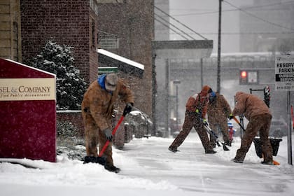 Trabajadores remueven la nieve de las veredas en Johnston, Pensilvania