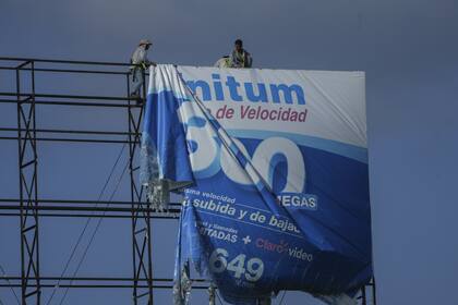 Trabajadores retiran un anuncio de un cartel de protección antes de la llegada prevista del huracán Beryl, en Playa del Carmen, México, el miércoles 3 de julio de 2024