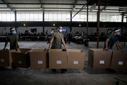 Trabajadores trasladan cajas con votos en Guarenas, Venezuela