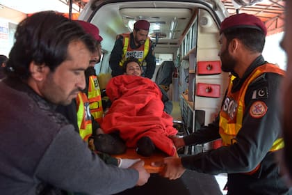 Trabajadores y voluntarios de Reducir transportan a una víctima herida de la explosión