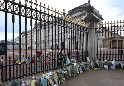 Tras conocerse la noticia de la muerte del príncipe Felipe de Edimburgo, las puertas del Palacio de Buckingham, en Londres, se llenaron de flores que acercaban las personas a modo de tributo. (Foto: Andy Rain/ EFE)