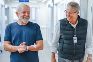 Tras la operación, Lula camina en uno de los pasillos del hospital junto a un médico