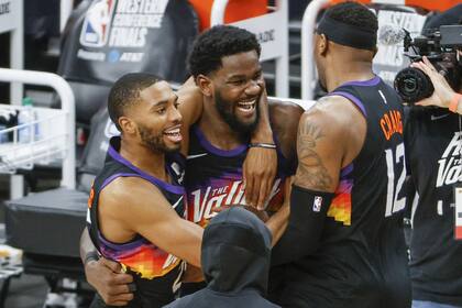 Tras la revisión de la jugada, Deandre Ayton se permite una sonrisa: lo acompañan Mikal Bridges y Torrey Craig; Phoenix dio un paso importante para conquistar la final del Oeste en la NBA
