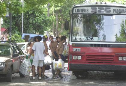 Tras un saqueo, un grupo de personas sube la mercadería robada a un colectivo que unía la zona oeste del Gran Buenos Aires con la Capital