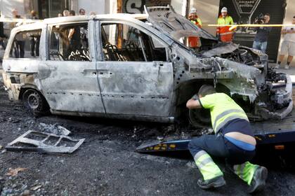 La basura y los autos incendiados son removidos de las calles de Barcelona.