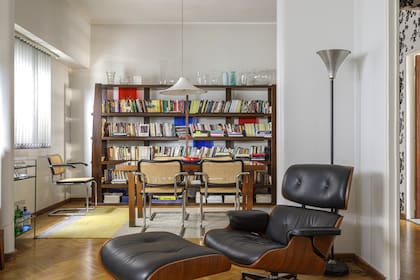 Tres elementos para un rincón de lectura perfecto: la biblioteca de madera y vidrio, la poltrona Eames tapizada en cuero y una lampara de pie vintage (Ejército de Salvación).