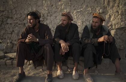 Tres hombres afganos se sientan afuera de una mezquita, el 27 de septiembre de 2021