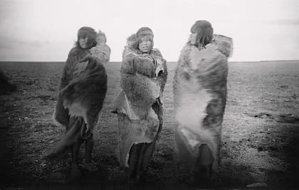 Tres indias onas en pieles, una con un niño, encontradas en Patagonia al final de la Expedición belga a la Antártida”. 1899.