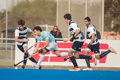 Tres jugadores de Quilmes persiguen a un rival de Santa Bárbara; el Cervecero ganó con lo justo