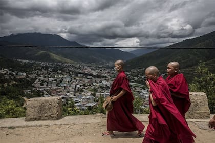 Tres monjes budistas recorren un camino de monta?a cercano al pueblo de Thimphu, en Bután