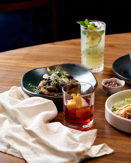 Trufa cuenta con un pequeño patio interno, un salón con cava y mesas en la vereda