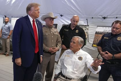 Trump escucha las explicaciones del gobernador de Texas, Greg Abbott, en Eagle Pass, Texas