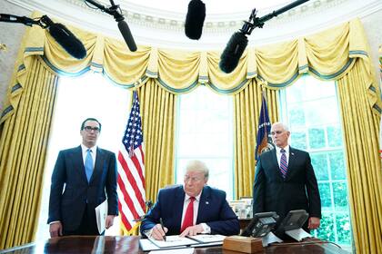 Trump firma con el vicepresidente Mike Pence (derecha) y el secretario del Tesoro de Estados Unidos, Steven Mnuchin, en la Casa Blanca, "sanciones contundentes" contra el líder supremo de Irán