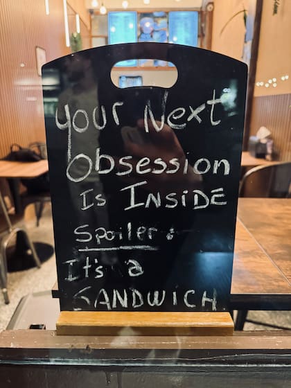 "Tu próxima obsesión está dentro. Spoiler: es un sándwich", dice uno de los letreros del local argentino