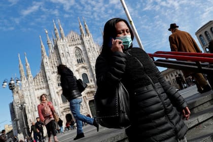 Turistas caminan por las calles de Milán, Italia, con barbijos