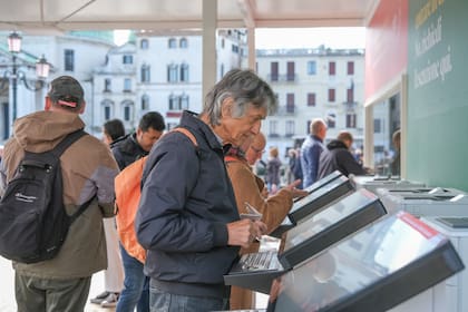 Turistas compran el ticket de 5 euros para ingresar a Venecia, el 25 de abril de 2024.  (Stefano Mazzola/Getty Images)