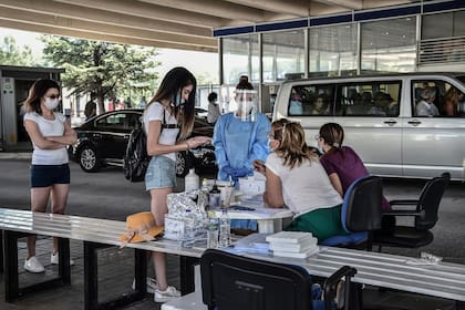 Turistas esperan recibir una prueba de coronavirus (PCR) en el cruce fronterizo griego-búlgaro en Promachonas el 10 de julio de 2020.